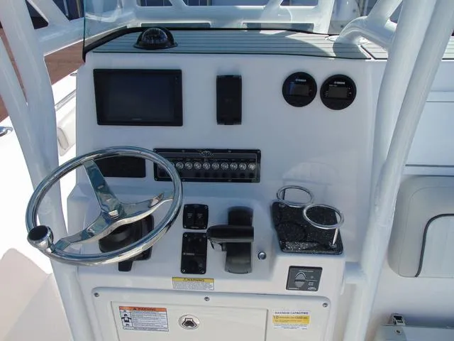 Slide: The Image of 2022 Sea Fox 249 Avenger boat console with steering wheel, gauges, and controls. - 11