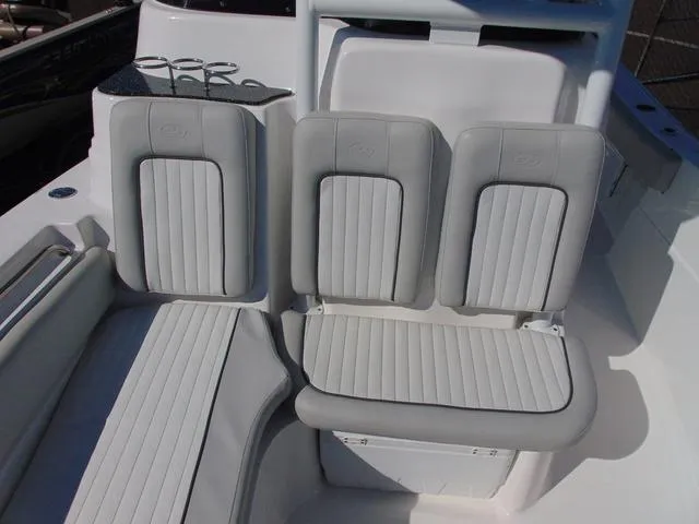 Slide: The Image of 2022 Sea Fox 249 Avenger boat seating with cup holders, featuring sleek white and gray design. - 19