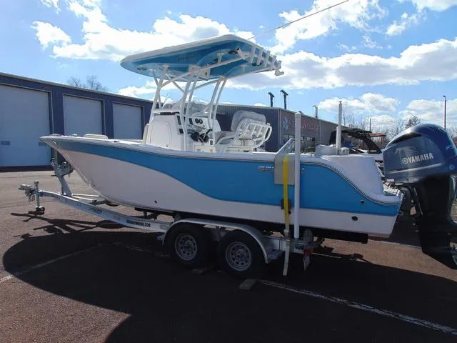 Slide: The Image of 2022 Sea Fox 249 Avenger boat on trailer, blue and white design, parked outdoors. - 3