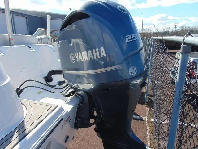 Slide: The Image of 2022 Sea Fox 249 Avenger with Yamaha 250 outboard motor, parked near a chain-link fence. - 6