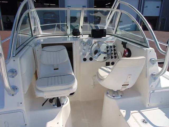 Slide: The Image of 2011 Sea Chaser 2100 Walk-Around boat cockpit with steering wheel and seating. - 9