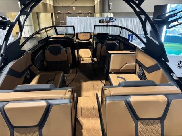 Slide: The Image of 2025 Yamaha Boats 255XD displayed indoors on a trailer, featuring sleek black design and tan seating. - 3