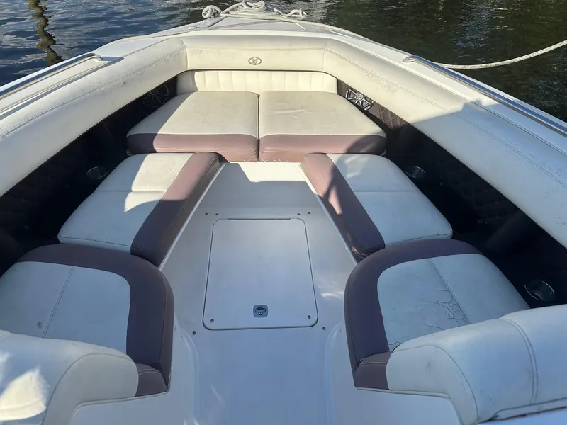 Slide: The Image of 2012 Cobalt 302 boat interior with white and beige seating, docked on water. - 21