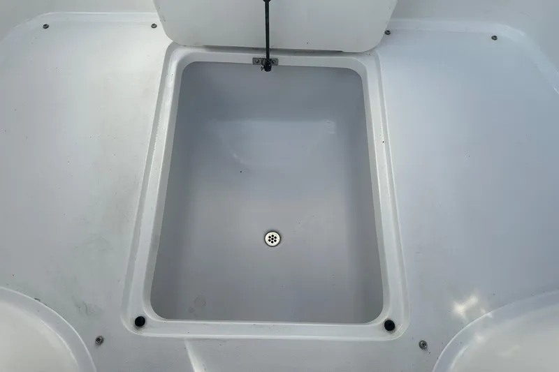 Slide: The Image of Storage compartment on a 2012 Cobalt 302 boat, featuring a drain plug. - 26