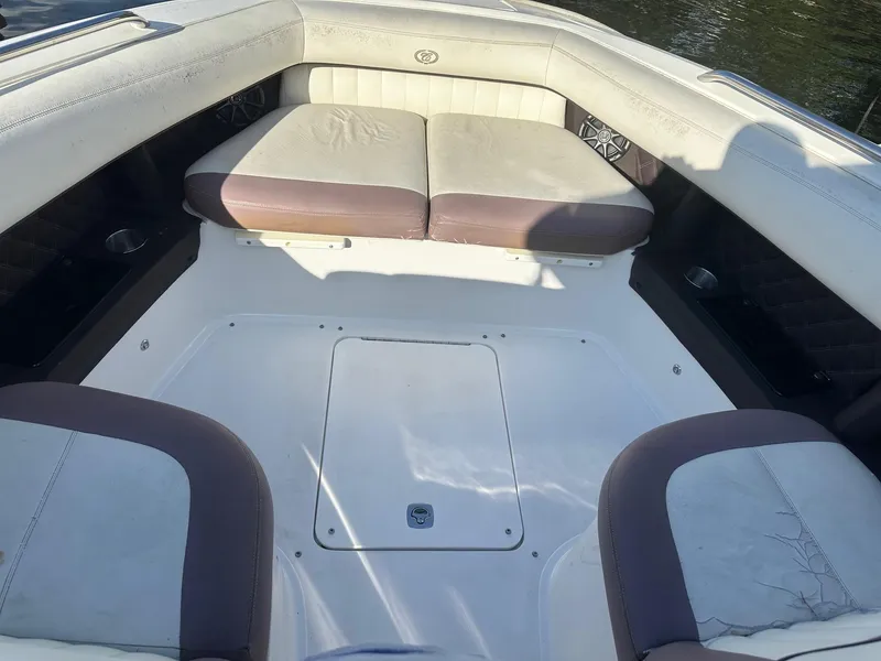 Slide: The Image of 2012 Cobalt 302 boat interior with cushioned seating and storage compartment. - 28
