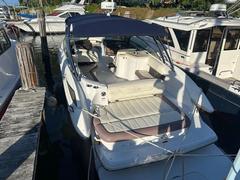 Slide: The Image of 2012 Cobalt 302 boat docked, featuring spacious seating and canopy. - 3