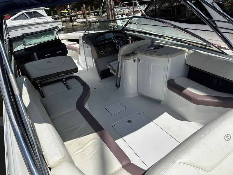 Slide: The Image of 2012 Cobalt 302 boat interior with white seating and helm, docked at marina. - 4