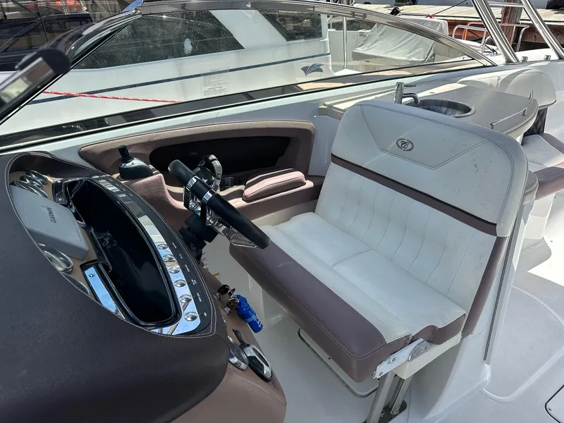 Slide: The Image of 2012 Cobalt 302 boat interior with steering wheel and white seating. - 8