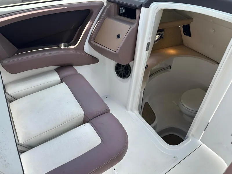 Slide: The Image of Interior of a 2012 Cobalt 302 boat featuring seating and a compact restroom. - 9