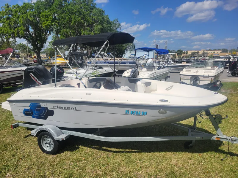 Slide: The Image of 2019 Bayliner Element E16 boat on trailer, parked on grass under a sunny sky. - 3