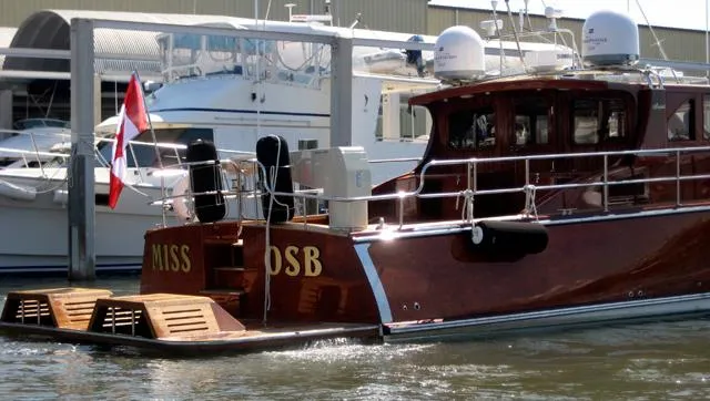 Slide: The Image of Luxury 2009 Hugh Saint 65 Commuter yacht docked, featuring polished wood finish and Canadian flag. - 6