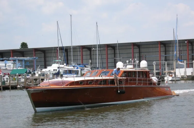 Slide: The Image of 2009 Hugh Saint 65 Commuter boat cruising near a marina with docked sailboats. - 8