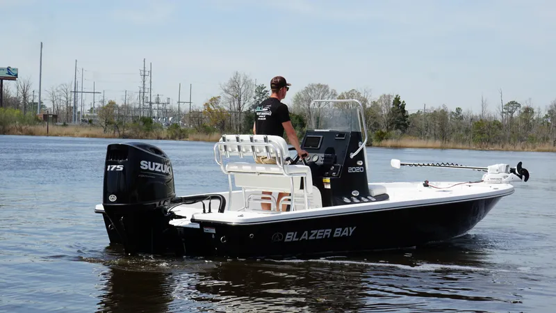 Slide: The Image of Man operating Blazer Bay 2020 boat with Suzuki engine on a calm river. - 5