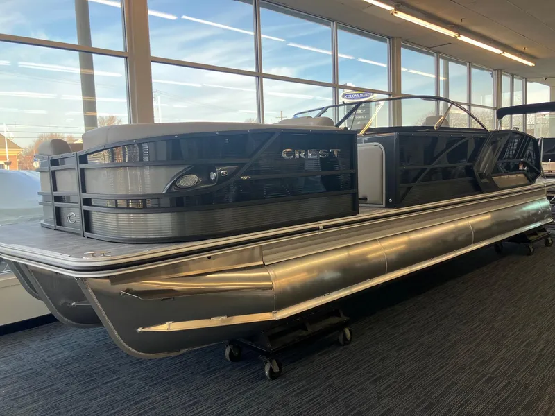 Slide: The Image of 2025 Crest Continental 250 SLS pontoon boat displayed indoors, showcasing sleek design and modern features. - 1