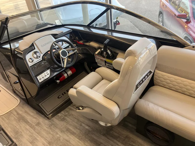Slide: The Image of 2025 Crest Continental 250 SLS boat interior with modern helm and comfortable seating. - 8