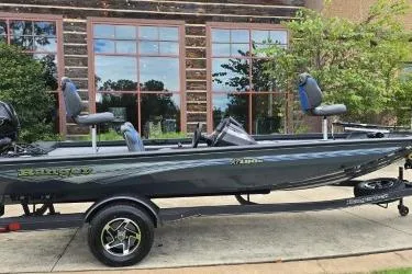 Slide: The Image of 2025 Ranger RT188C fishing boat parked outdoors with modern design and seating. - 1