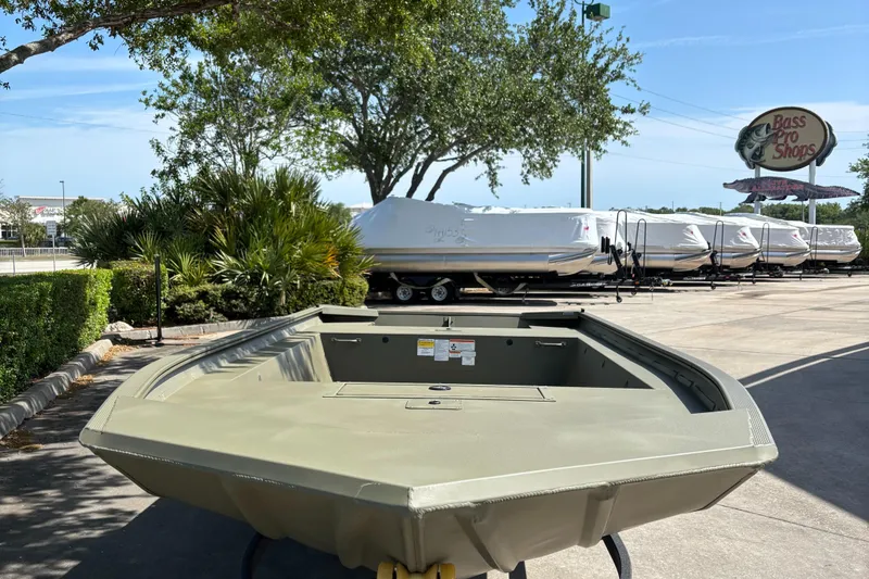 Slide: The Image of 2025 Tracker Grizzly 1754 Jon boat displayed outdoors at a dealership. - 2