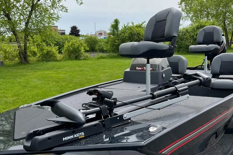 Slide: The Image of 2025 Tracker Bass Tracker Classic XL boat with Minn Kota trolling motor on grassy area. - 2