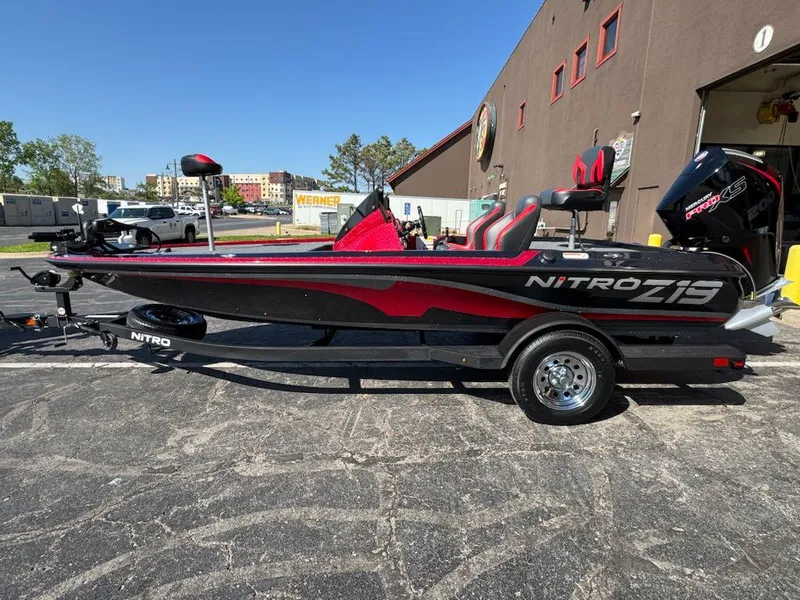 Slide: The Image of 2025 Nitro Z19 boat with trailer, black and red design, parked outdoors. - 2