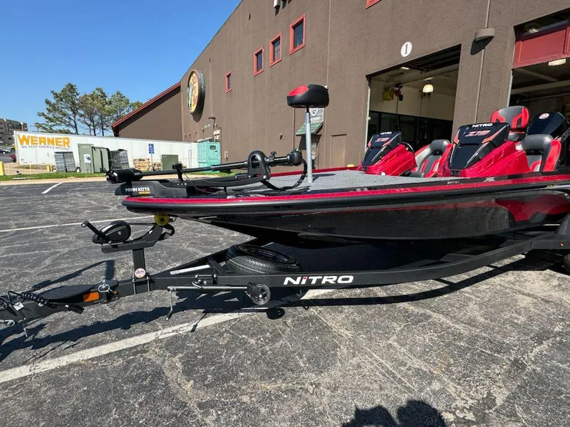 Slide: The Image of 2025 Nitro Z19 boat with red seats parked outside a building on a sunny day. - 3