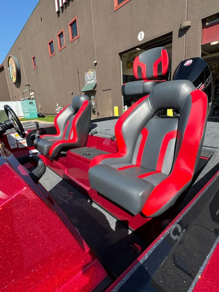 Slide: The Image of 2025 Nitro Z19 boat with red and gray seats, parked outside a building. - 5