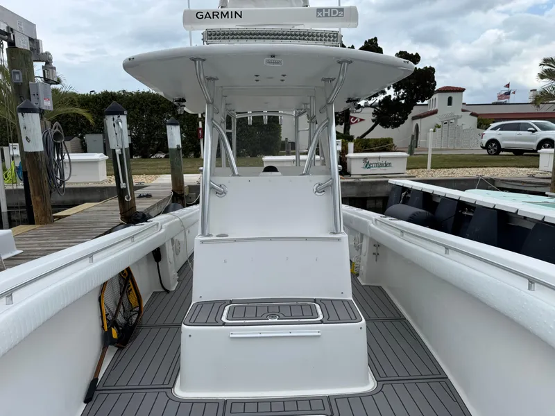 Slide: The Image of 2004 Palmetto 33 Adventure boat docked, featuring Garmin equipment and spacious deck. - 13