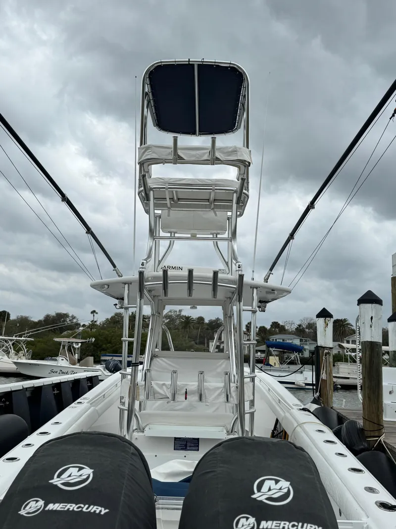 Slide: The Image of 2004 Palmetto 33 Adventure boat with dual Mercury engines, docked under cloudy skies. - 18