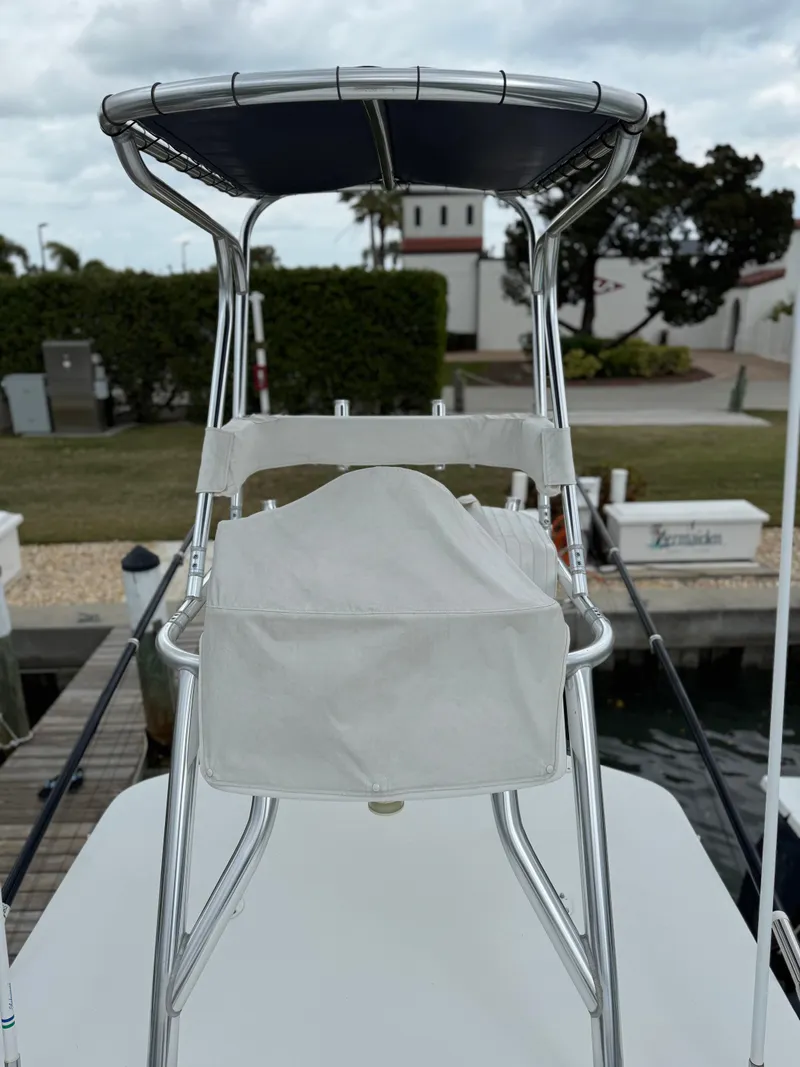 Slide: The Image of 2004 Palmetto 33 Adventure boat with T-top and seating, docked near a residential area. - 7