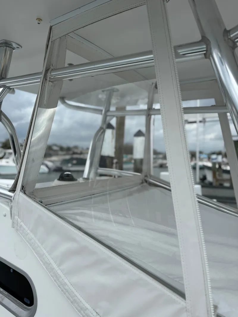 Slide: The Image of 2004 Palmetto 33 Adventure boat with clear enclosure and marina background. - 9
