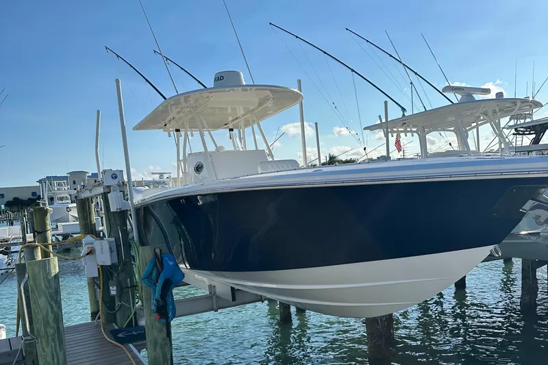 Slide: The Image of 2006 Island Runner 35 boat docked at marina, blue and white hull, clear sky background. - 1