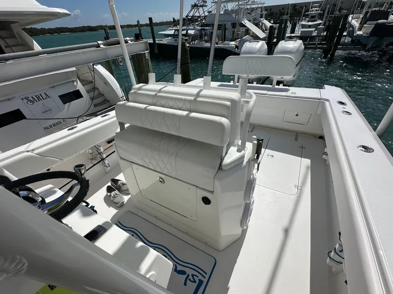 Slide: The Image of 2006 Island Runner 35 boat interior with white seating and steering wheel, docked at marina. - 14