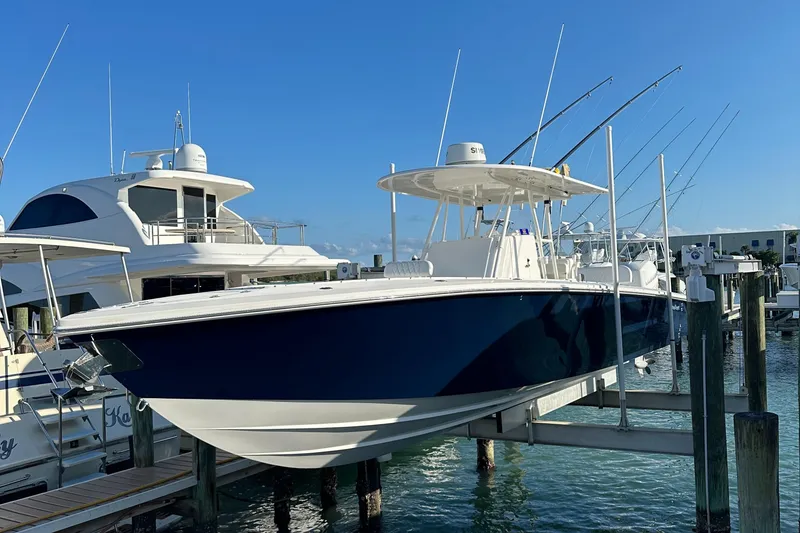 Slide: The Image of 2006 Island Runner 35 boat docked at marina, clear blue sky background. - 2