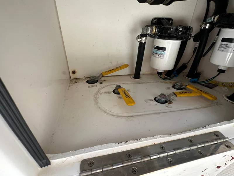 Slide: The Image of 2006 Island Runner 35 boat compartment with fuel filters and yellow-handled valves. - 27