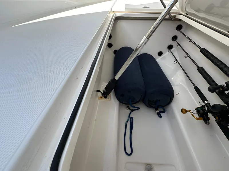 Slide: The Image of Storage compartment of 2006 Island Runner 35 with fishing rods and blue fenders. - 40