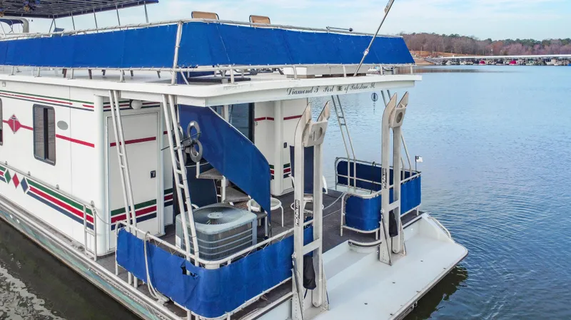 Slide: The Image of 1997 Stardust Cruisers 72x16 houseboat with blue canopy on a calm lake. - 10