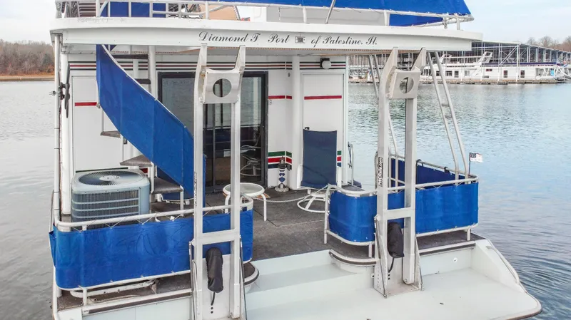 Slide: The Image of Houseboat Stardust Cruisers 72x16, 1997 model, with blue accents on a calm lake. - 11