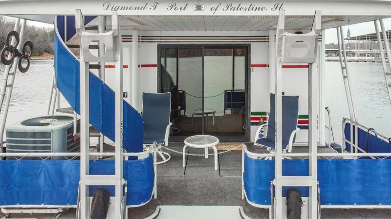 Slide: The Image of 1997 Stardust Cruisers 72x16 houseboat with blue slide and outdoor seating on a lake. - 12