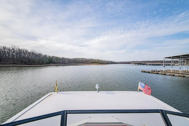 Slide: The Image of Front view from 1997 Stardust Cruisers 72x16 houseboat on a serene lake. - 13