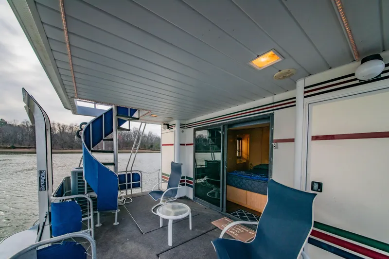 Slide: The Image of 1997 Stardust Cruisers 72x16 houseboat deck with spiral staircase and seating area. - 22