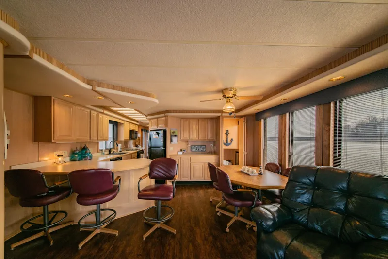 Slide: The Image of Interior of 1997 Stardust Cruisers 72x16 houseboat with kitchen, dining area, and seating. - 27