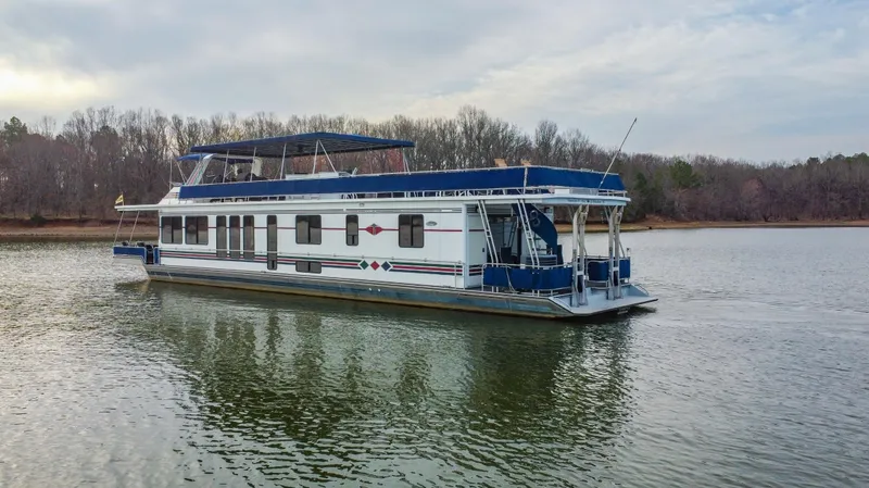 Slide: The Image of Houseboat on a lake, 1997 Stardust Cruisers 72x16, with blue and white design. - 3