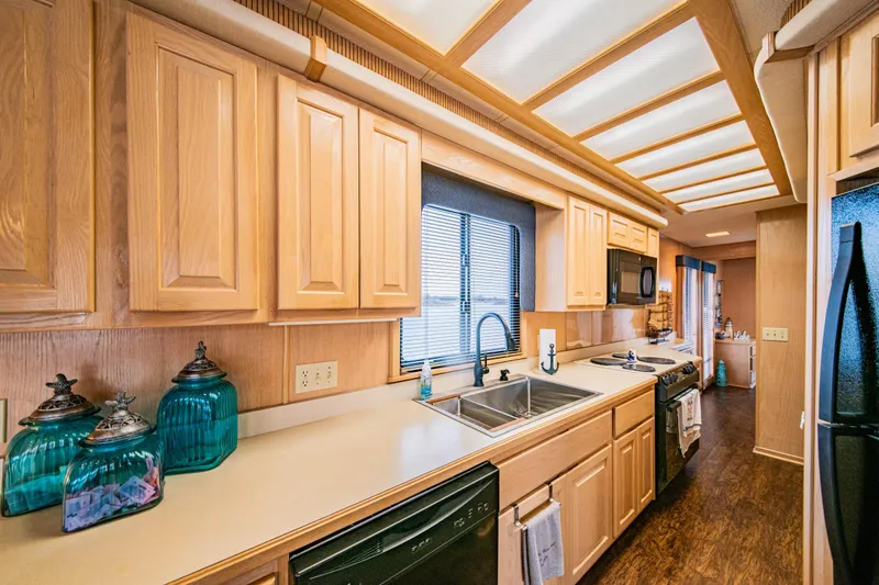 Slide: The Image of Houseboat kitchen with wooden cabinets, dual sinks, and modern appliances in a 1997 Stardust Cruisers 72x16. - 33