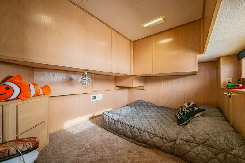 Slide: The Image of Cozy bedroom in 1997 Stardust Cruisers 72x16 houseboat with wood paneling and plush bedding. - 40