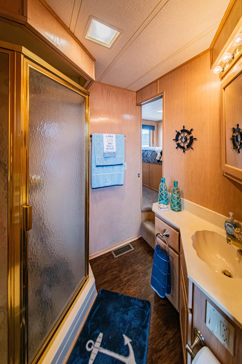 Slide: The Image of Bathroom interior of 1997 Stardust Cruisers 72x16 houseboat, featuring nautical decor and shower. - 42