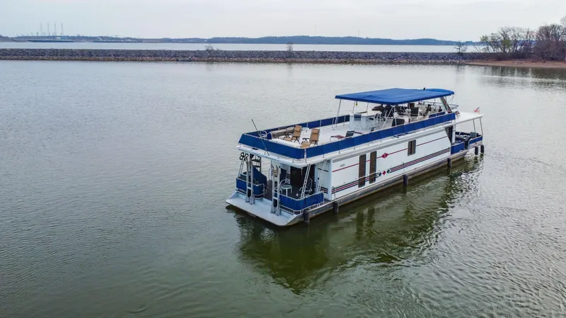 Slide: The Image of 1997 Stardust Cruisers 72x16 houseboat with blue canopy on a calm lake. - 8