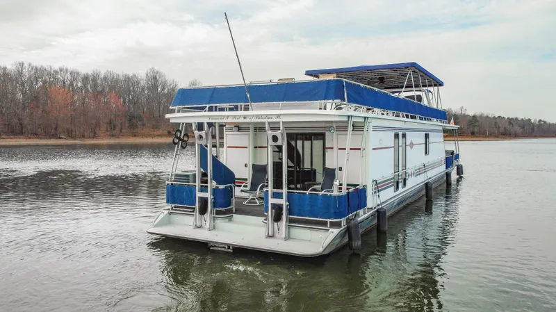 Slide: The Image of 1997 Stardust Cruisers 72x16 houseboat on a calm lake with wooded shoreline. - 9