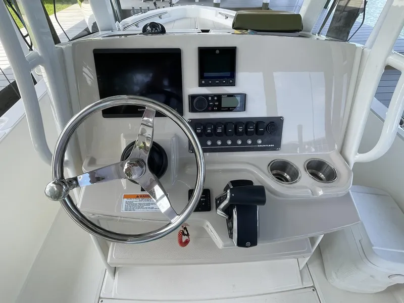 Slide: The Image of 2022 Boston Whaler 220 Dauntless boat console with steering wheel and control panel. - 12