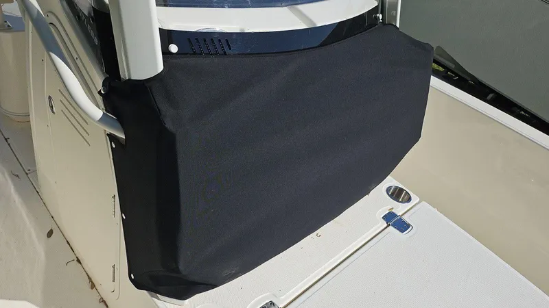 Slide: The Image of 2022 Boston Whaler 220 Dauntless console cover, black fabric, on a boat deck. - 23