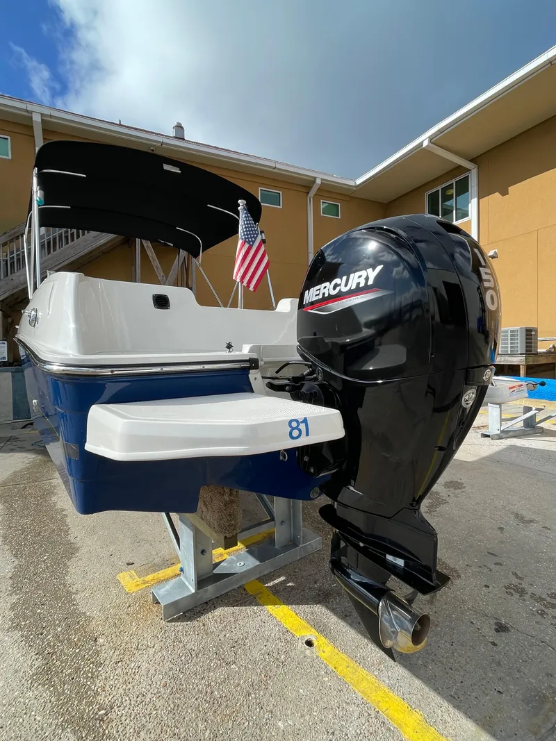 Slide: The Image of 2021 Bayliner Element E21 boat with Mercury outboard motor, docked near buildings. - 11