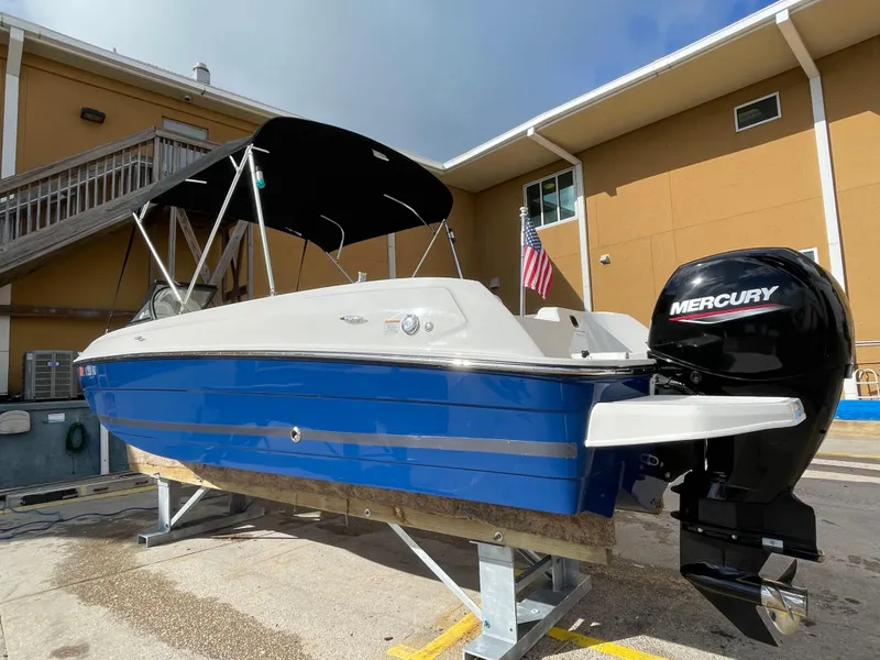 Slide: The Image of 2021 Bayliner Element E21 boat with Mercury engine, blue hull, docked outdoors. - 12